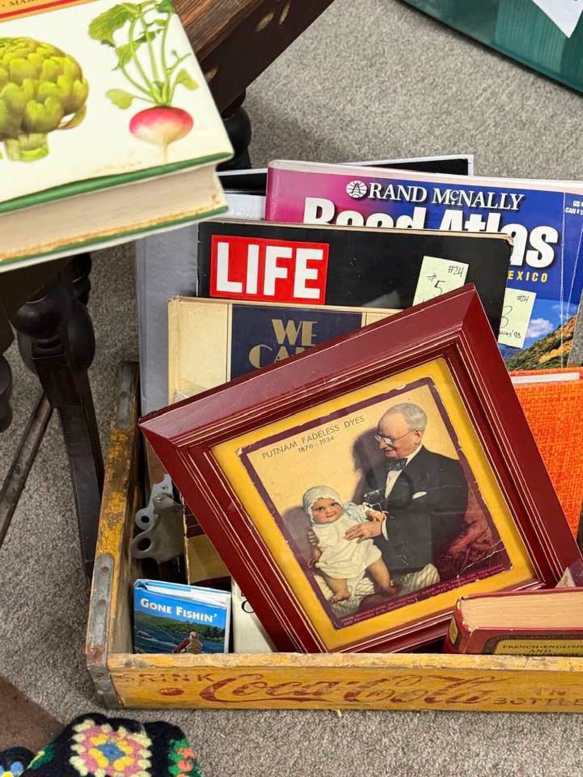 A crate of vintage LIFE magazines, a road atlas, and framed ephemera